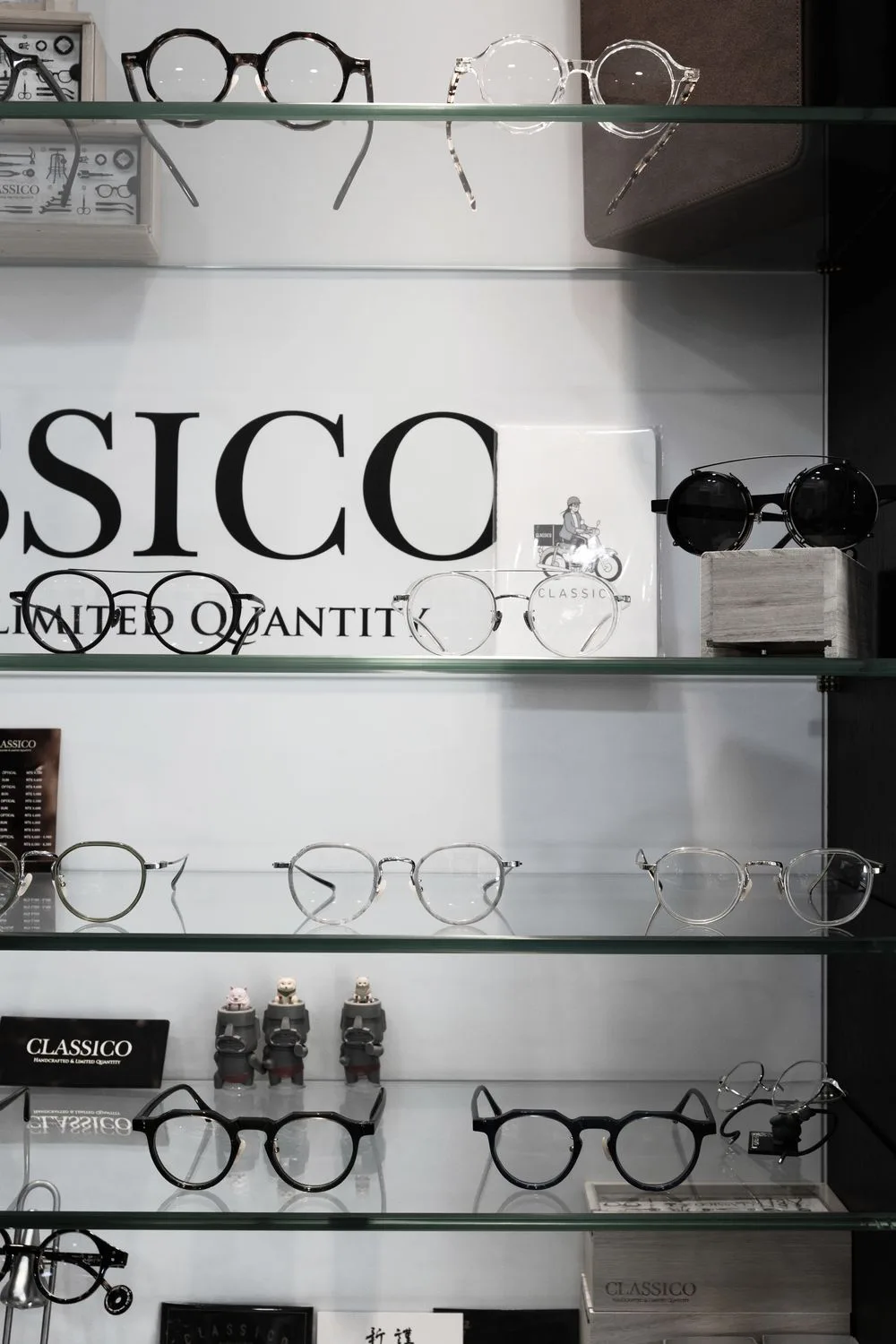 CLASSICO 陳列櫃特寫:前掛式墨鏡、金屬圓框與品牌型錄