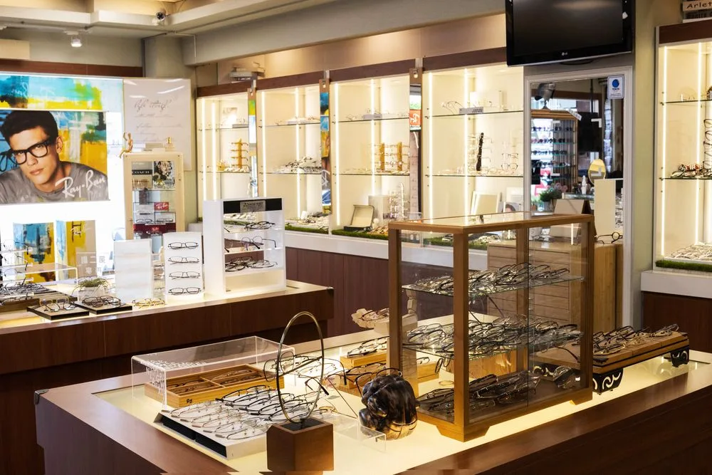 店內全景:Ray-Ban 海報牆、木質展示櫃與中央玻璃陳列桌