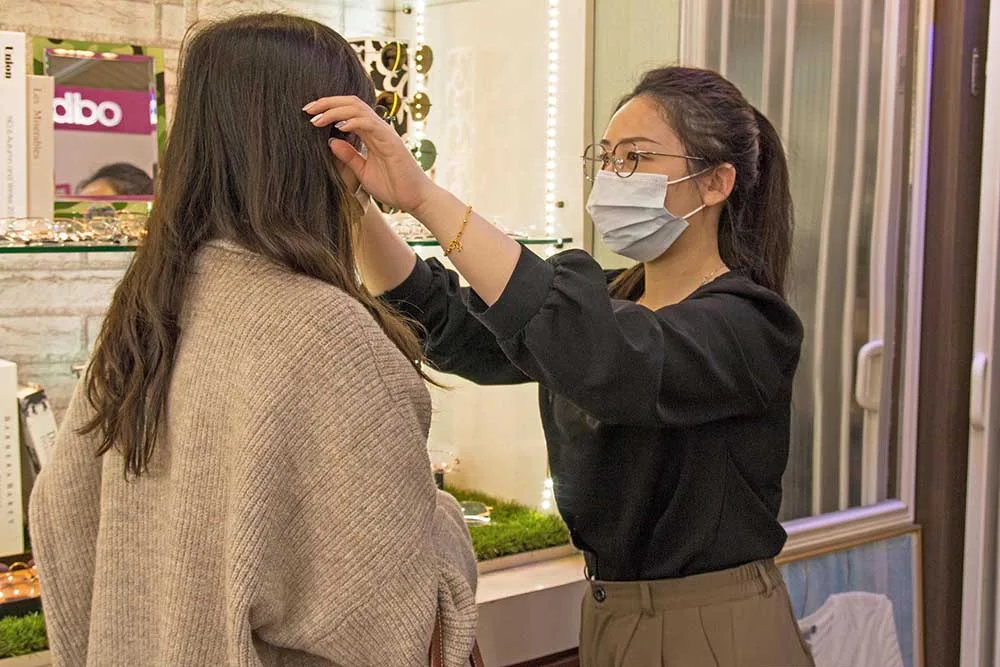 店員為顧客撥整頭髮準備試戴眼鏡