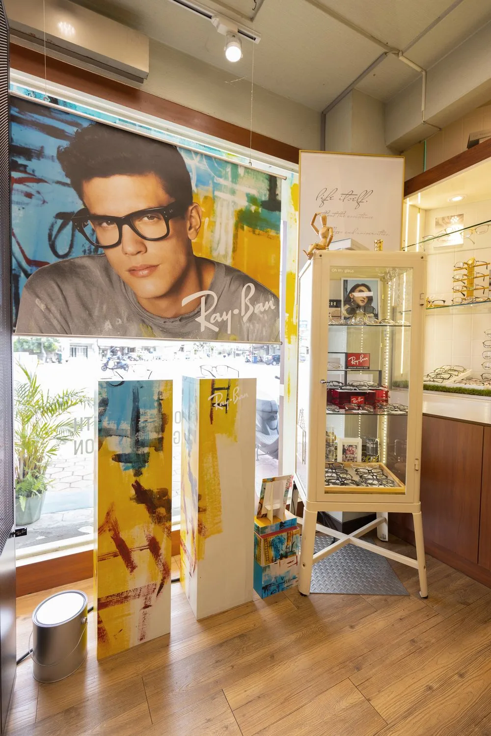 Ray-Ban 大幅海報下的品牌立牌與奶油色陳列櫃一角