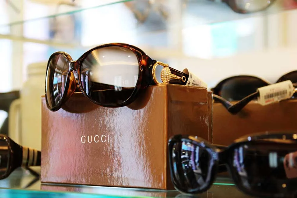 GUCCI 玳瑁色大框墨鏡與品牌紙盒的玻璃層架陳列
