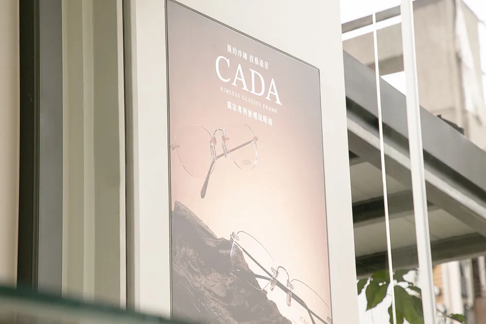 店門旁的 CADA 無螺絲眼鏡品牌燈箱海報