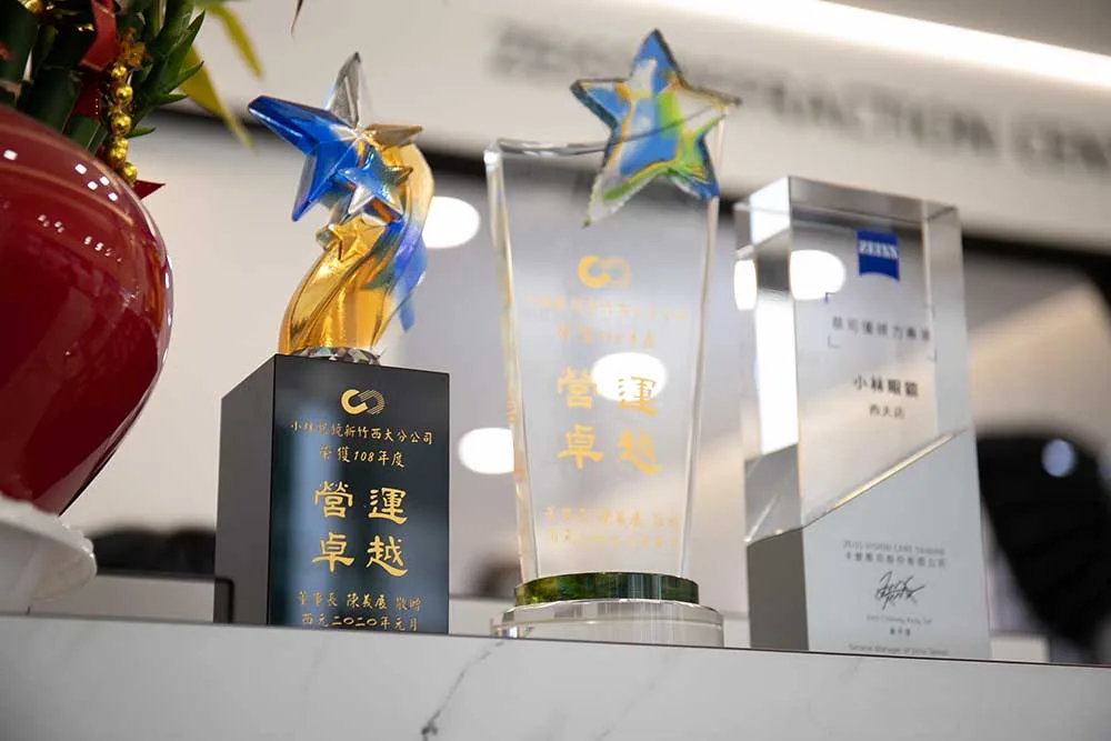 櫃檯上的營運卓越水晶獎座與蔡司優視力專家認證獎牌
