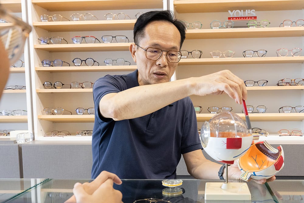 舒視驗光所創始人陳進發以模型向顧客說明